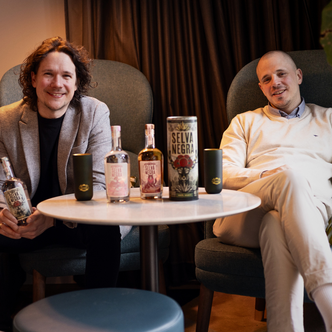 LAURIN LEHMANN UND SEBASTIAN DRESEL MIT PRODUKTEN AUF SESSELN AN TISCH